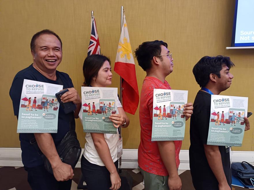 Four people holding up a Plastic Free July pledges