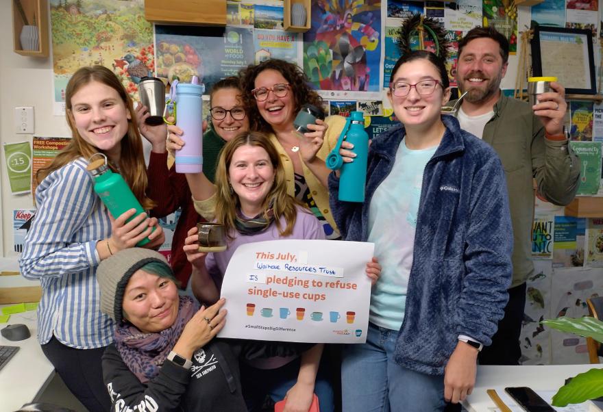 A group of people holding up a Plastic Free July pledge