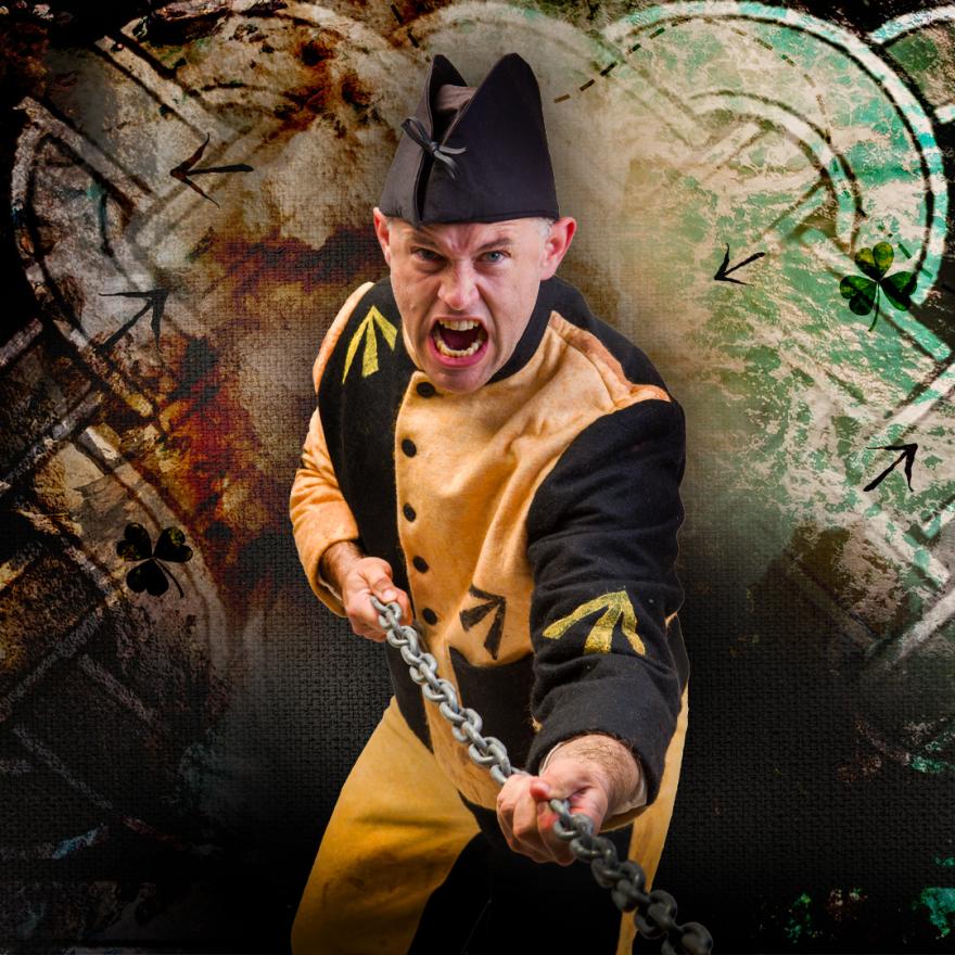 Man in a yellow and black costume pulling a chain, with a textured, abstract background.