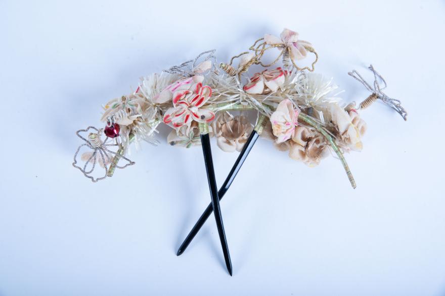 A headdress with an assortment of metal and fabric flower decorations.