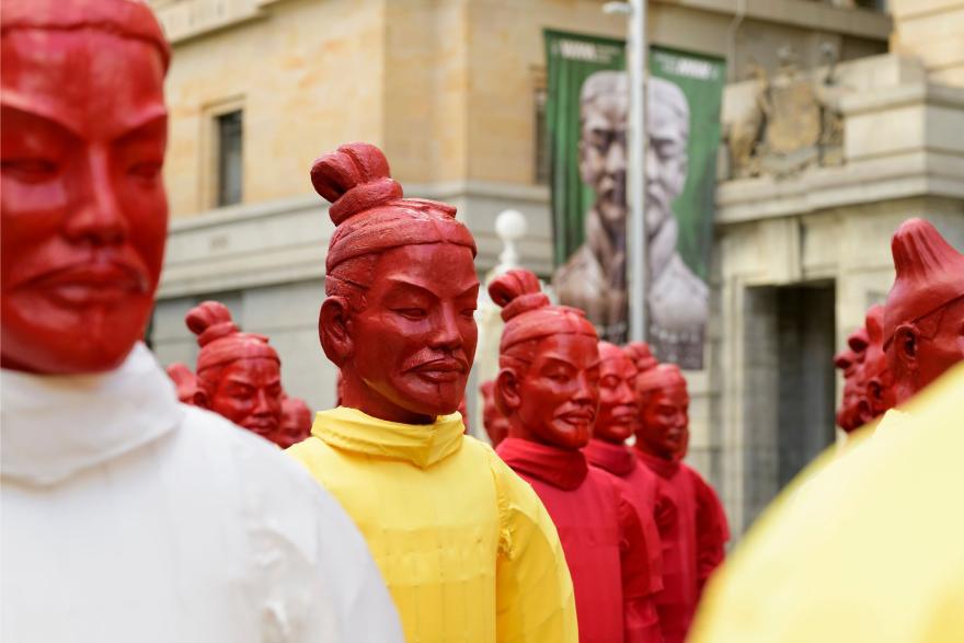 Close-up of colourful Terracotta Warrior lanterns in red and yellow displayed outdoors near a historic building