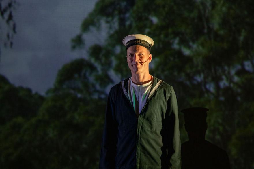 a person smiles and they are wearing a sailors uniform 