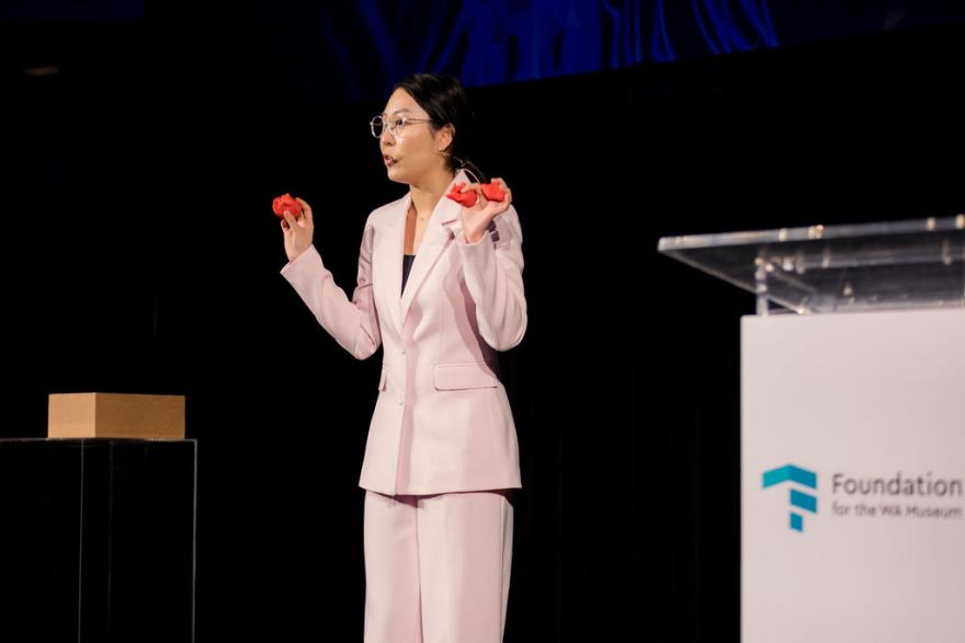 A woman on stage in a pink suit