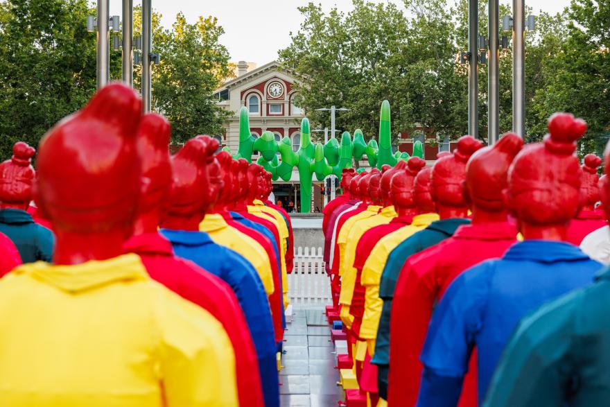 Bright coloured lanterns in the shape of silk warriors standing in formation in front of Perth's green cactus statue