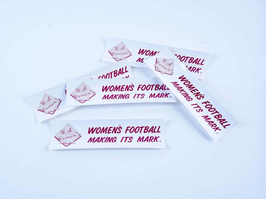 Five bumper stickers reading "women's football making its mark."