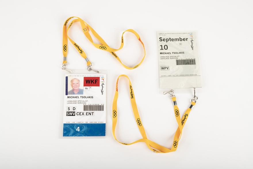Two identification cards for the 2000 Sydney Olympics on yellow lanyards.