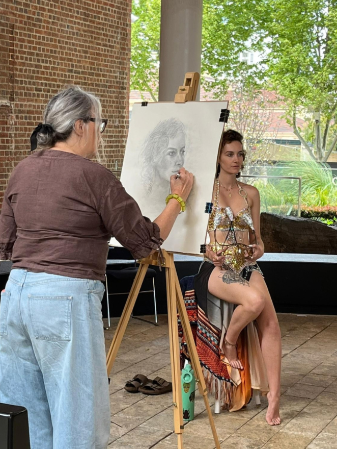 Artist drawing a model in graphite