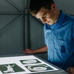 A young person looking at images on a lightbox