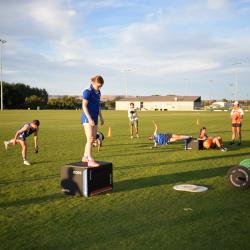 A group of people on a sports field performing various training activities