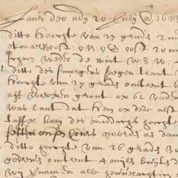 Close-up of an aged handwritten historical manuscript with faded ink, dense cursive text, and visible wear on parchment.