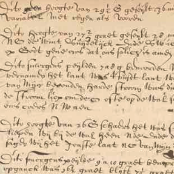 Close-up of an aged handwritten historical manuscript with faded ink, dense cursive text, and visible wear on parchment.