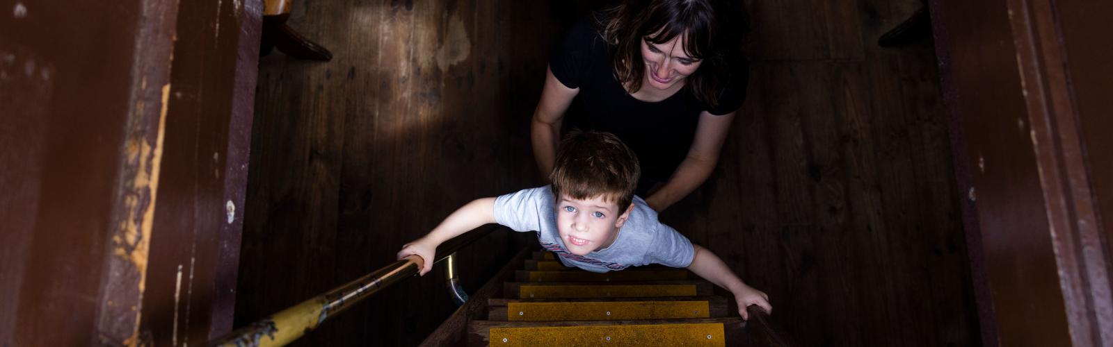 A child and adult climbing a steep set of stairs