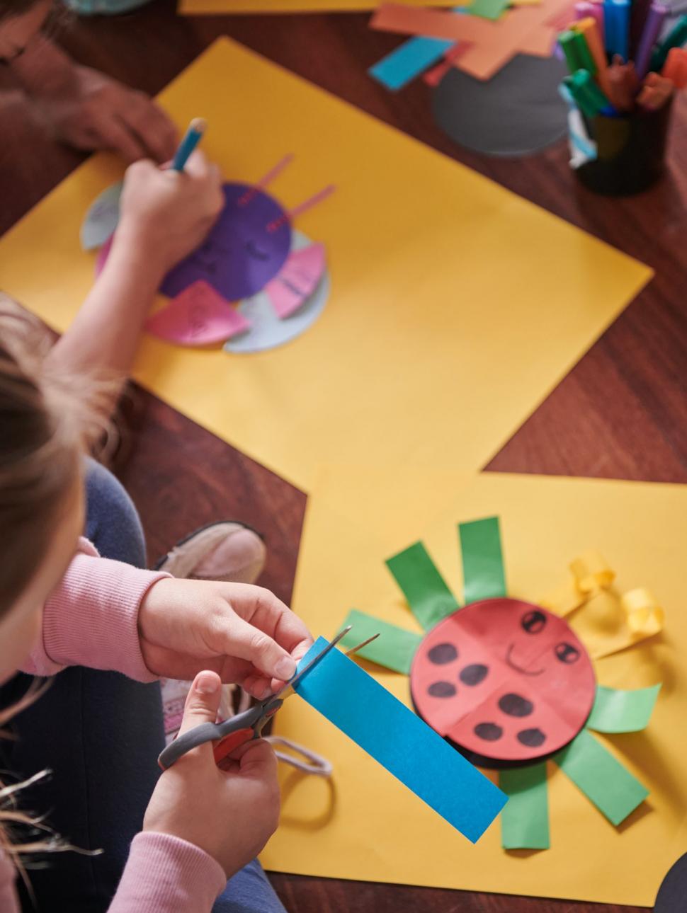 A child cutting out their own insect creation