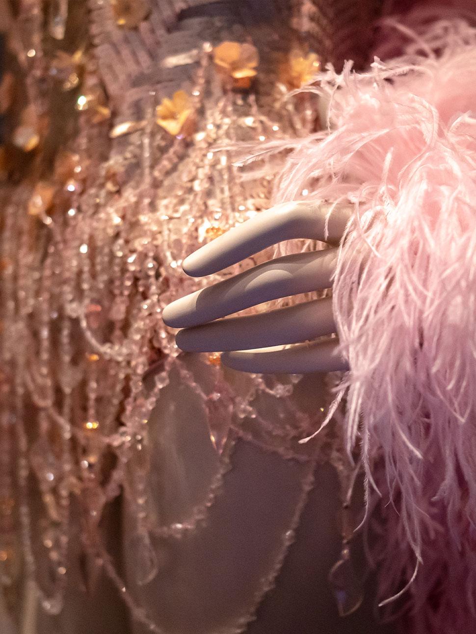 A close-up view of part of a costume covered in beads, sequins and feathers