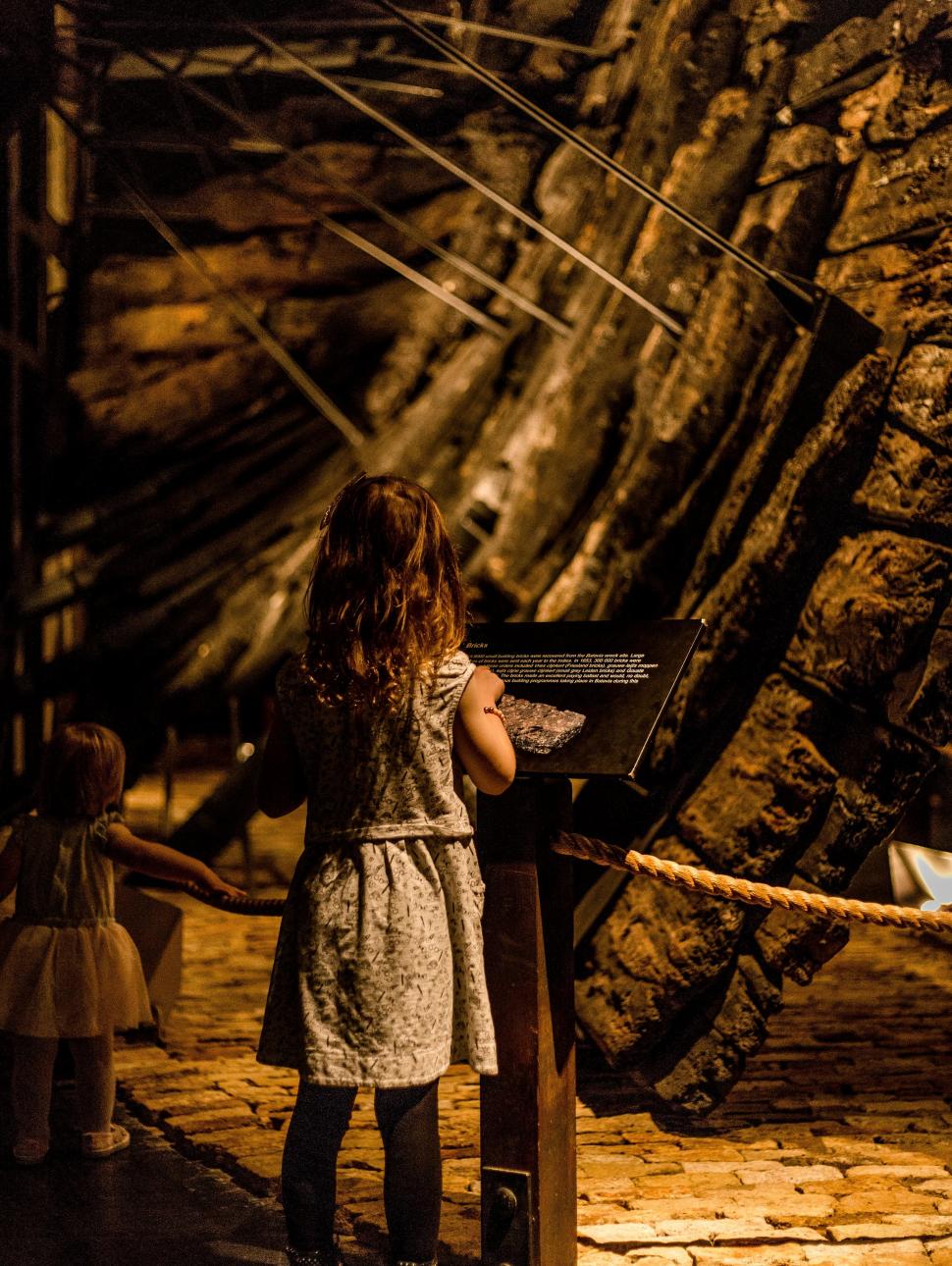 A girl stands touching a display sign in the Batavia Gallery