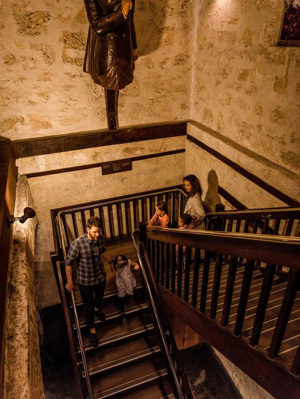 Two families walk down a wooden staircase