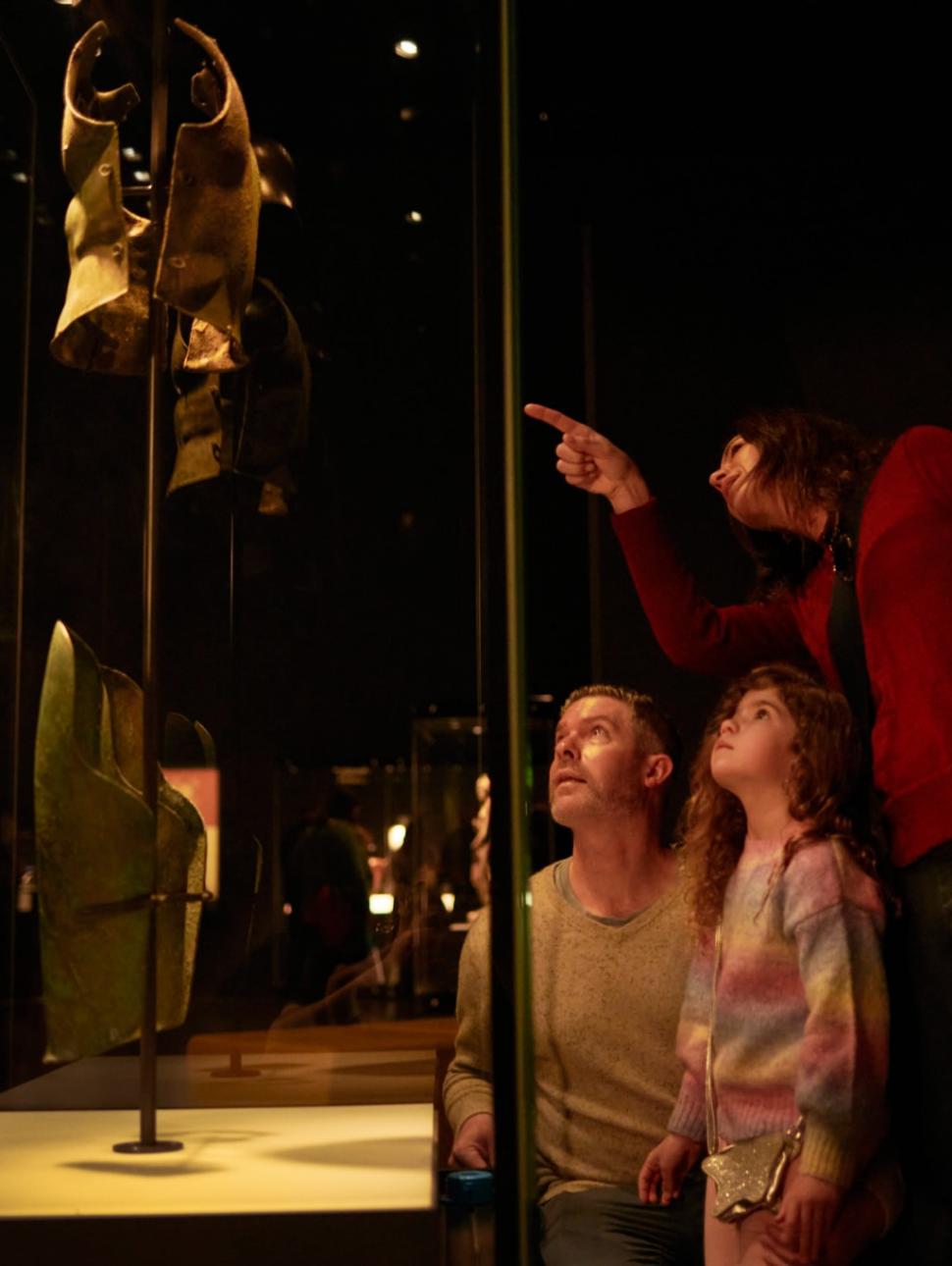 A family admiring a cabinet in Ancient Greeks exhibition