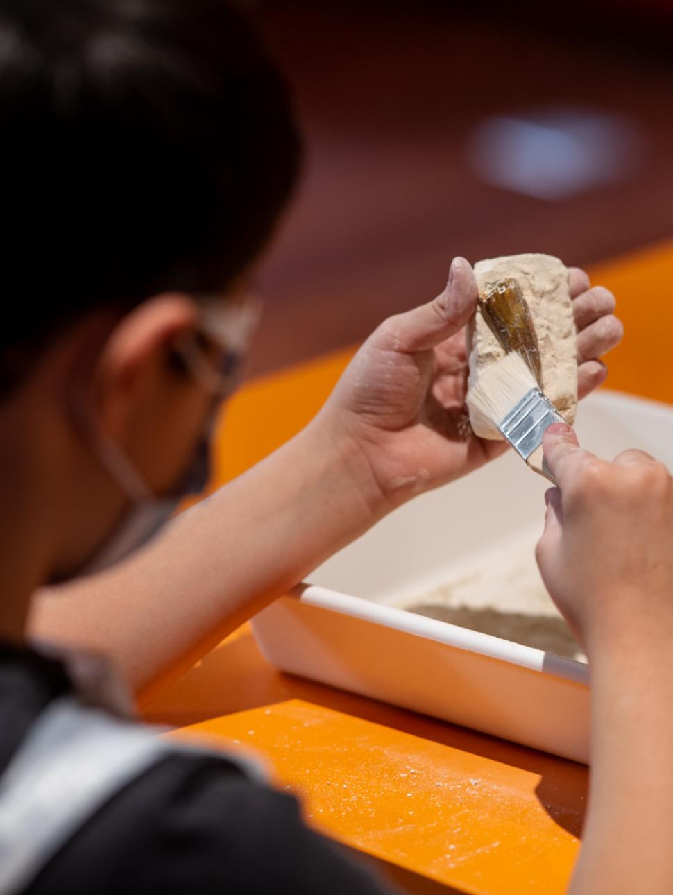 A child excavating a piece of pottery