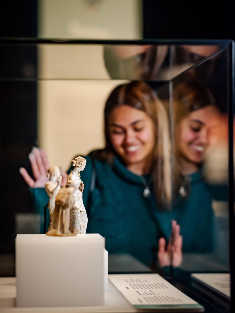 A female visitor looking at sculptures of women