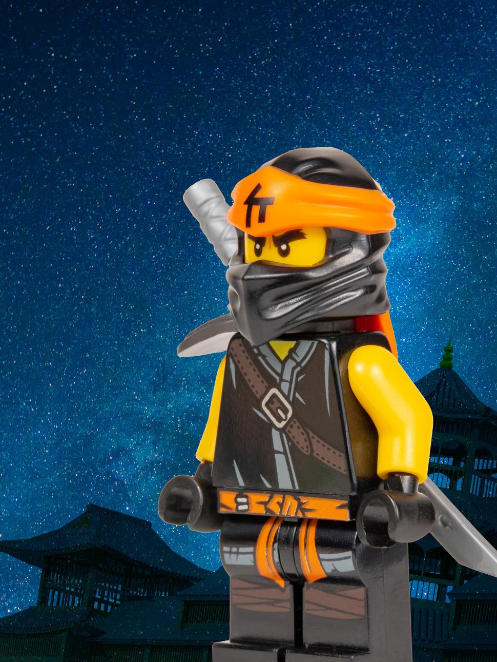 A LEGO minifigure of a ninja pictured against a starry sky