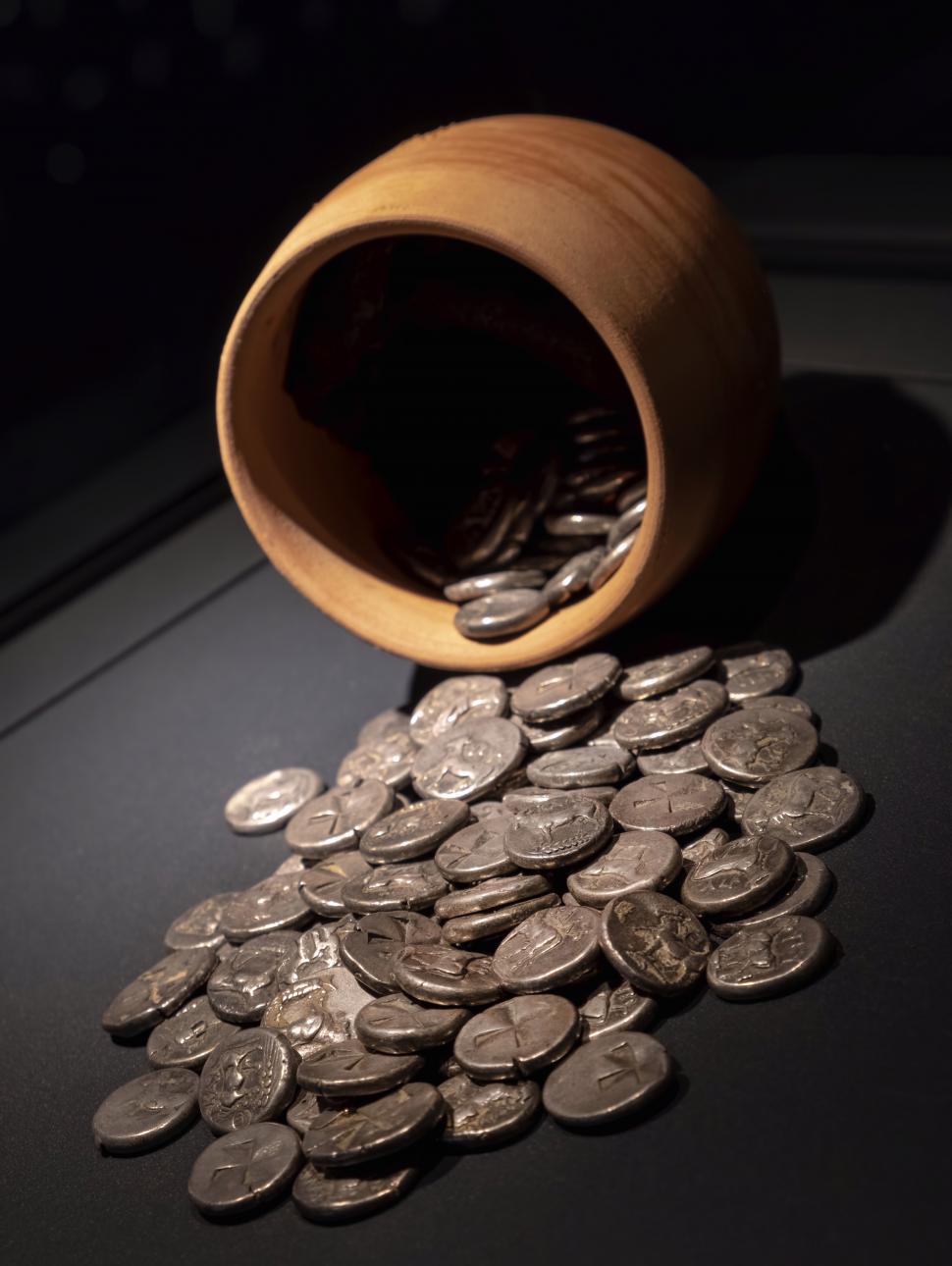 Image of old coins falling off a vase