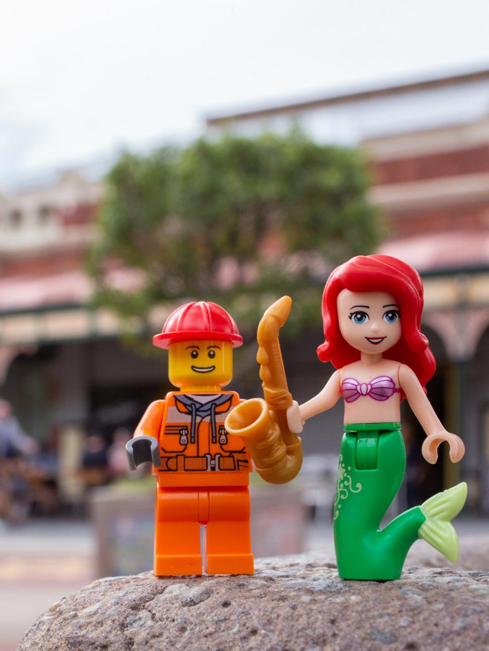 Two LEGO figures are posed on the street in front of the Fremantle Markets