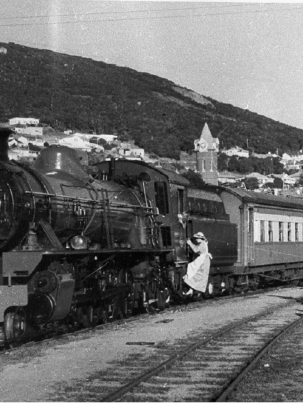 A black-and-white photograph of people boarding a train