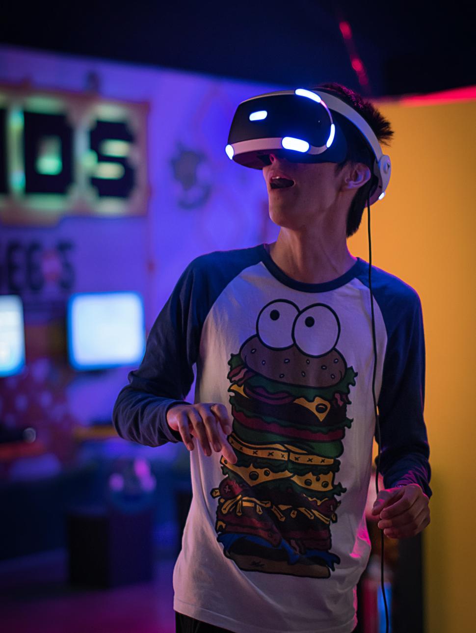 Young individuals experience wearing a VR headset surrounded by illuminated lighting 