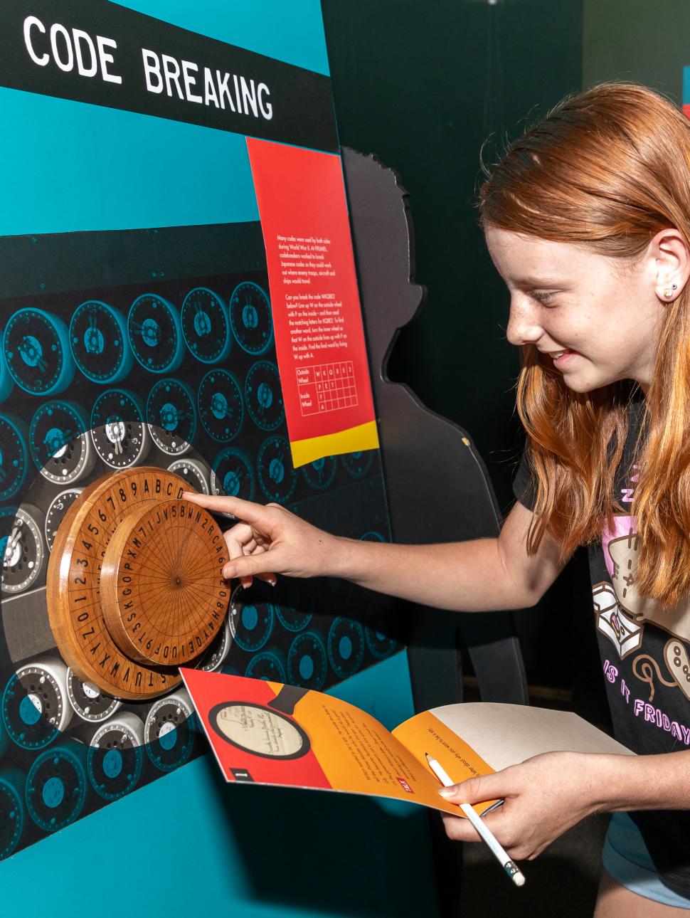 An image of young girls interacting with a wooden cod wheel