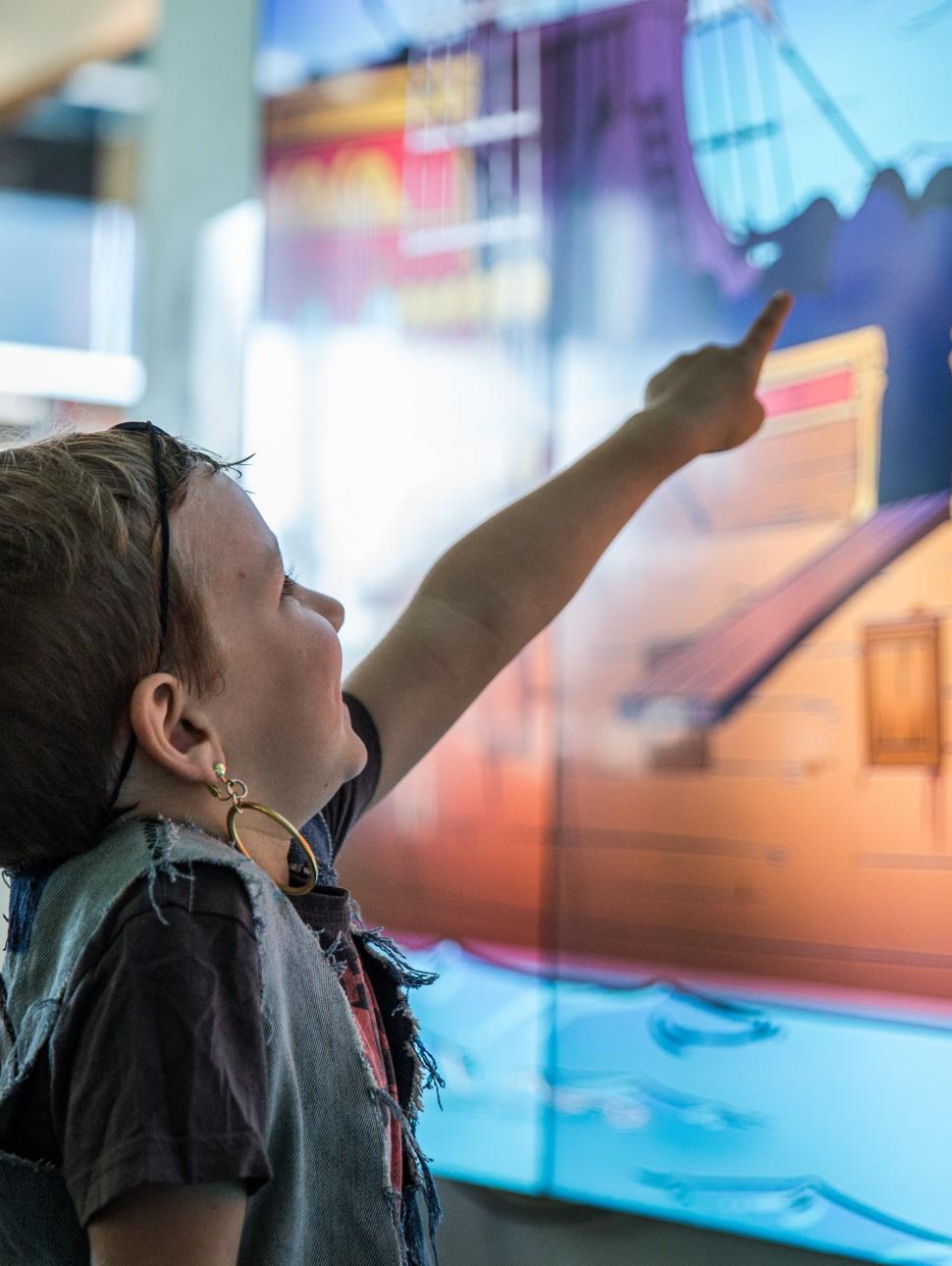 Young child points at a pirate ship