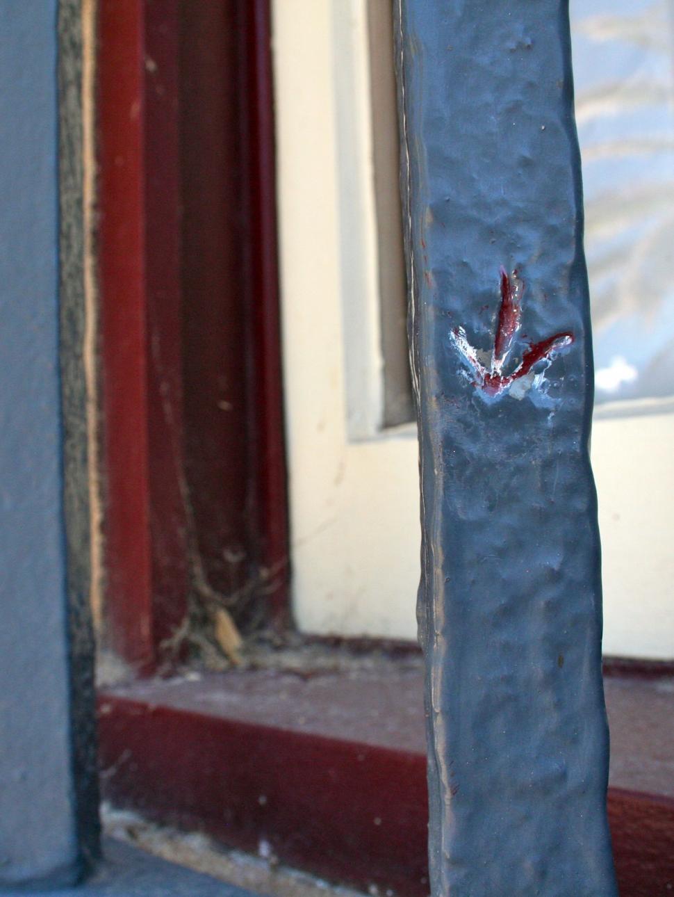 A broad arrow carved into a window bar of the WA Shipwrecks Museum
