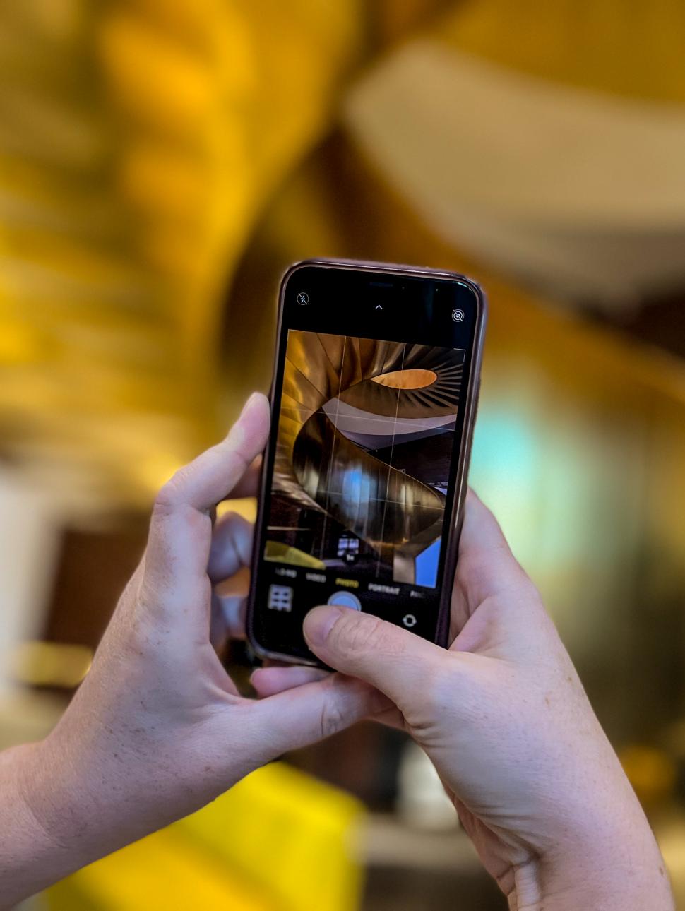 Image of a person capturing images on their phone with WA Museum in the background