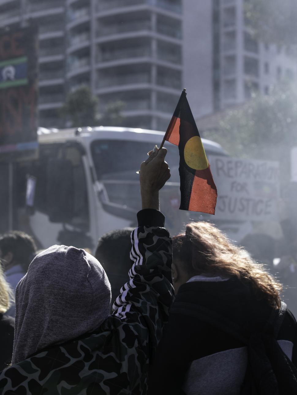 Image of an Indigenous flag amongst people in a march 