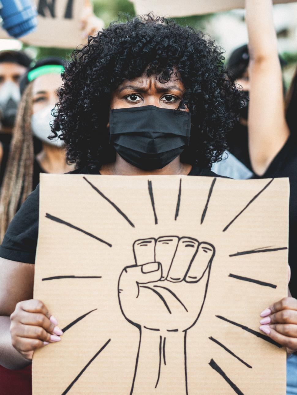 woman holds cardboard power symbol