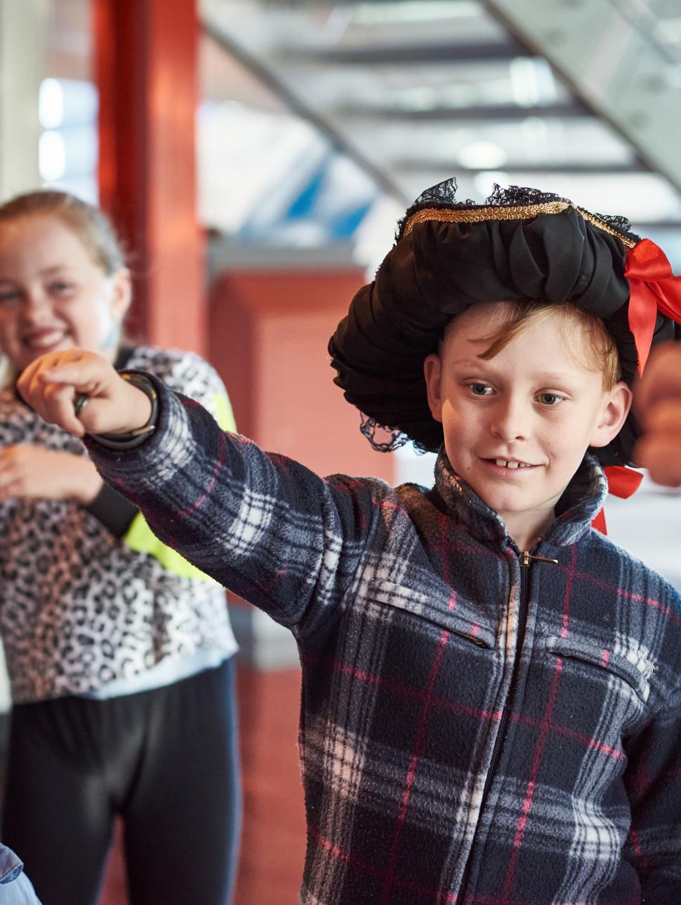 Image of a young child wearing a captains hat 