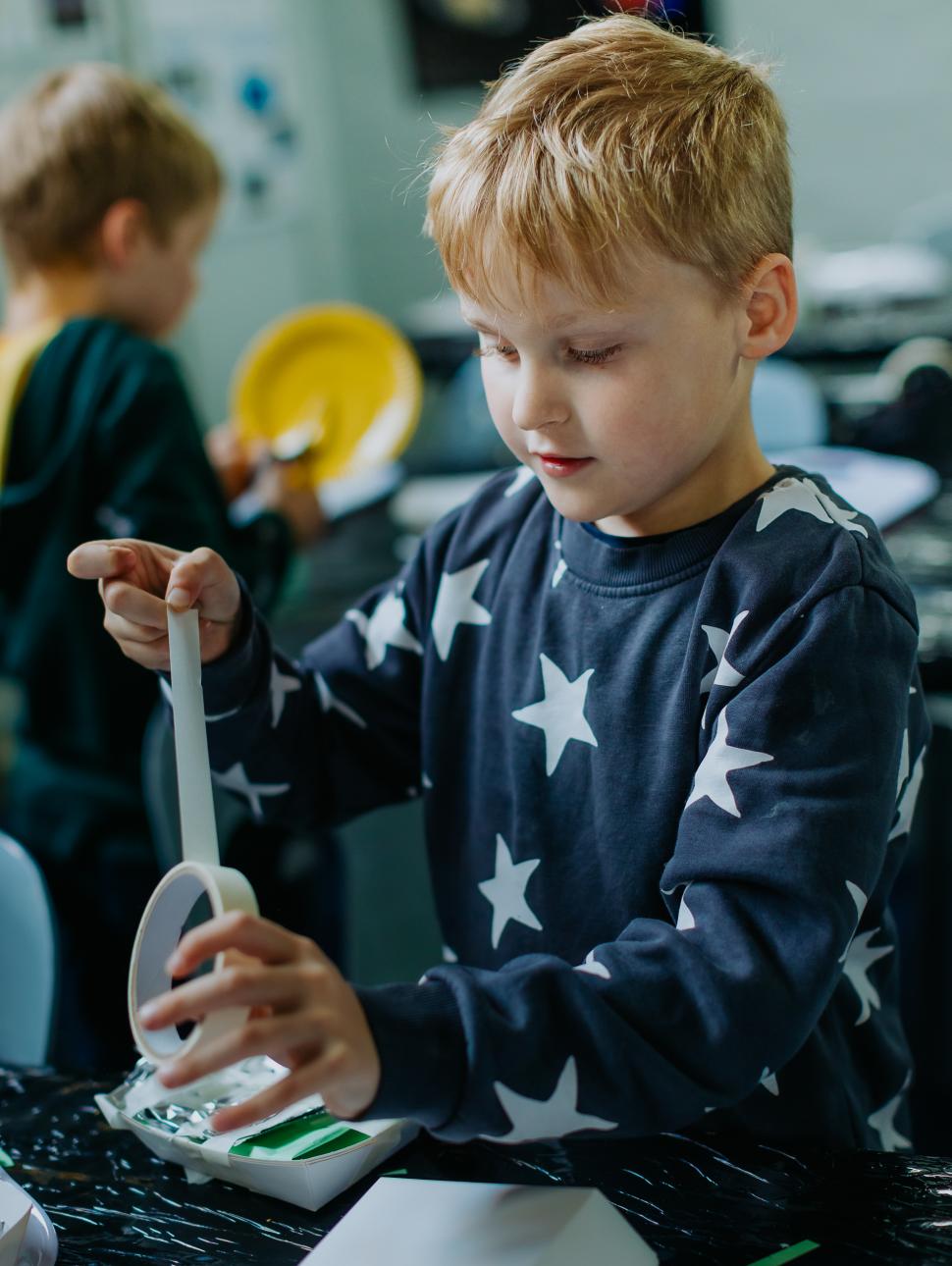 A young child builds an space object