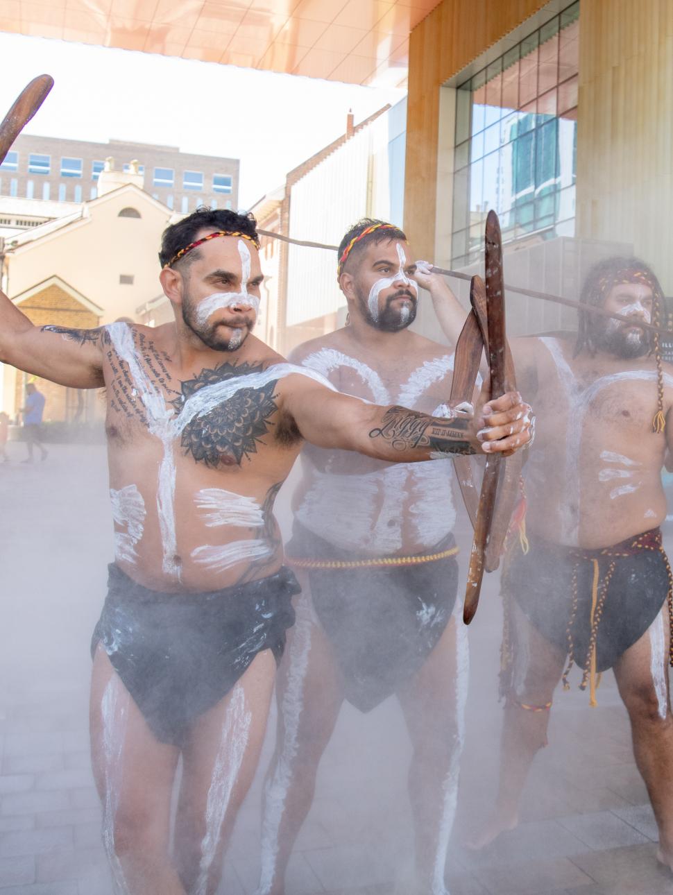 Aboriginal men painted and holding traditional objects 