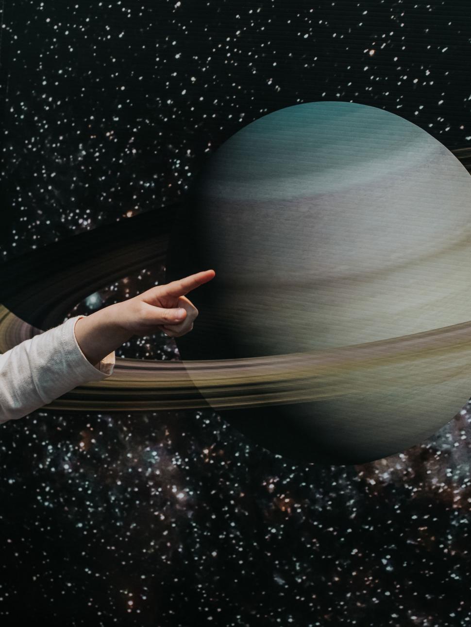 Hand pointing at planet