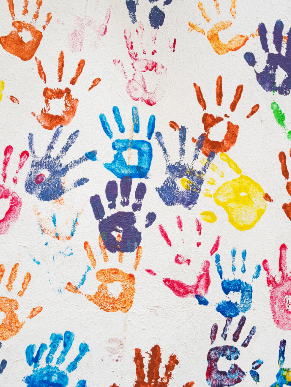 Coloured paint hand prints on white textured wall