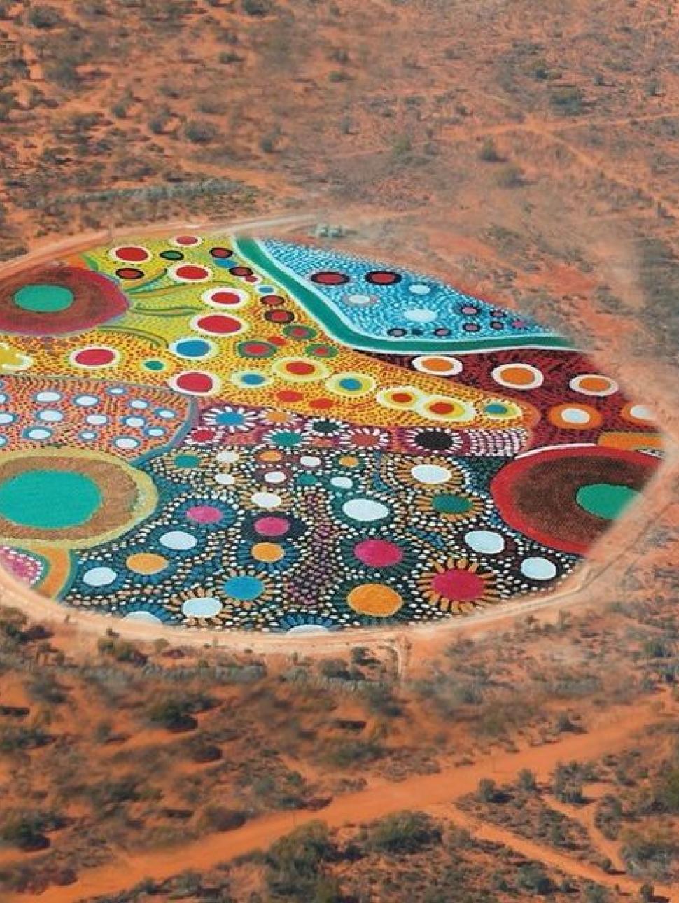 In image of a colourful painting placed in the middle of an rural ariel shot from Kalgoorlie.