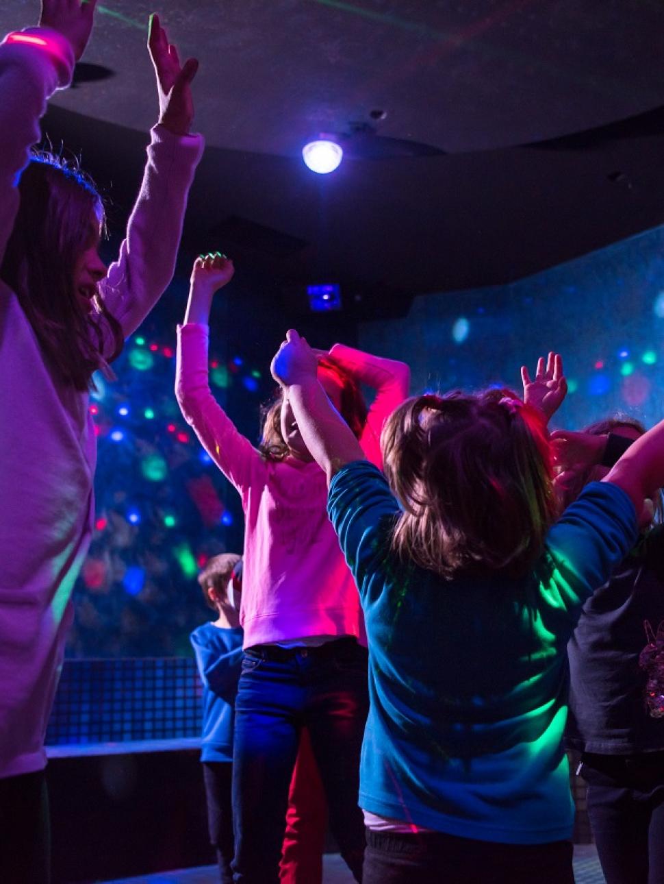 A group of children dance at a disco