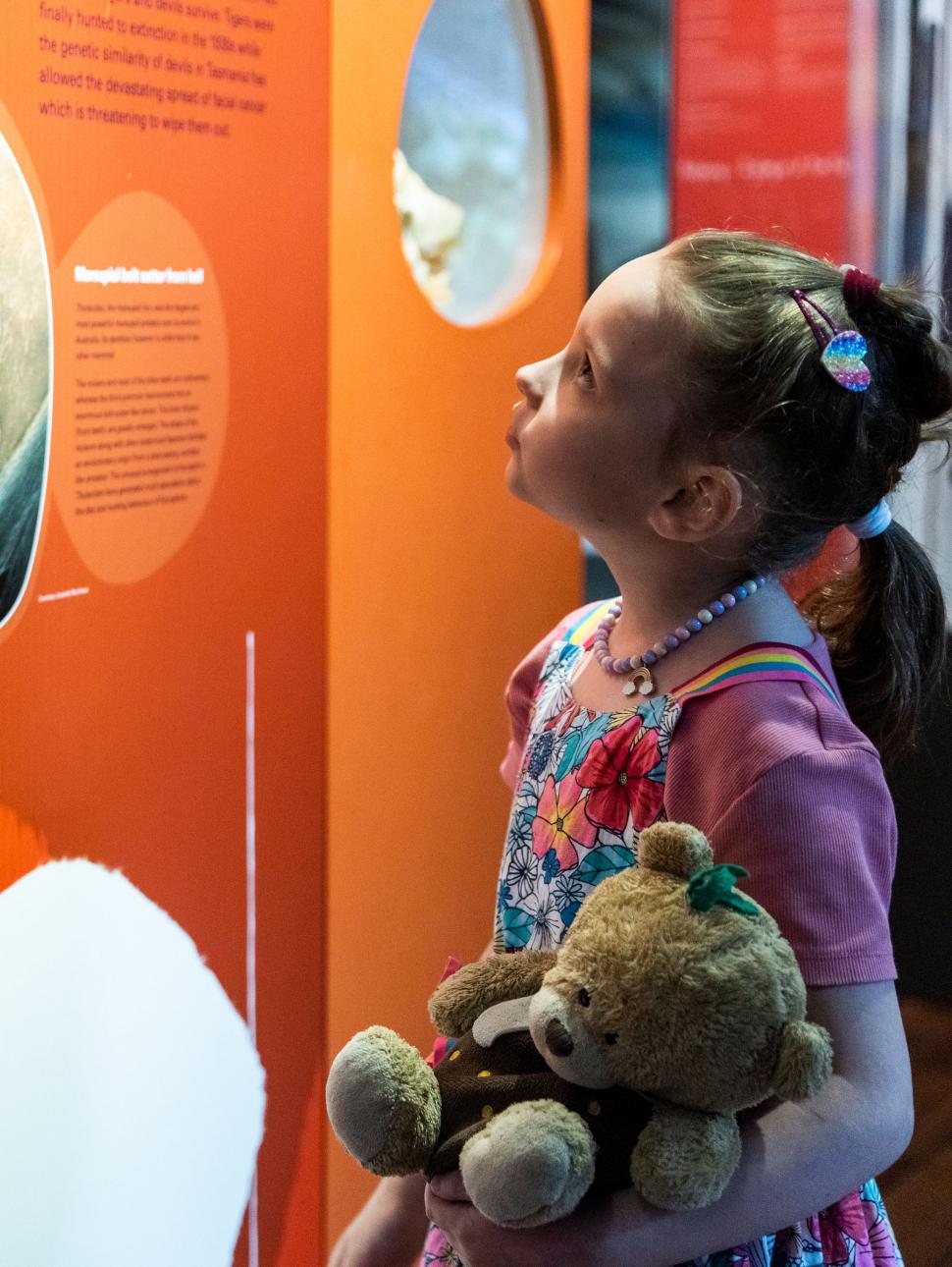 young girl stares at orange wall