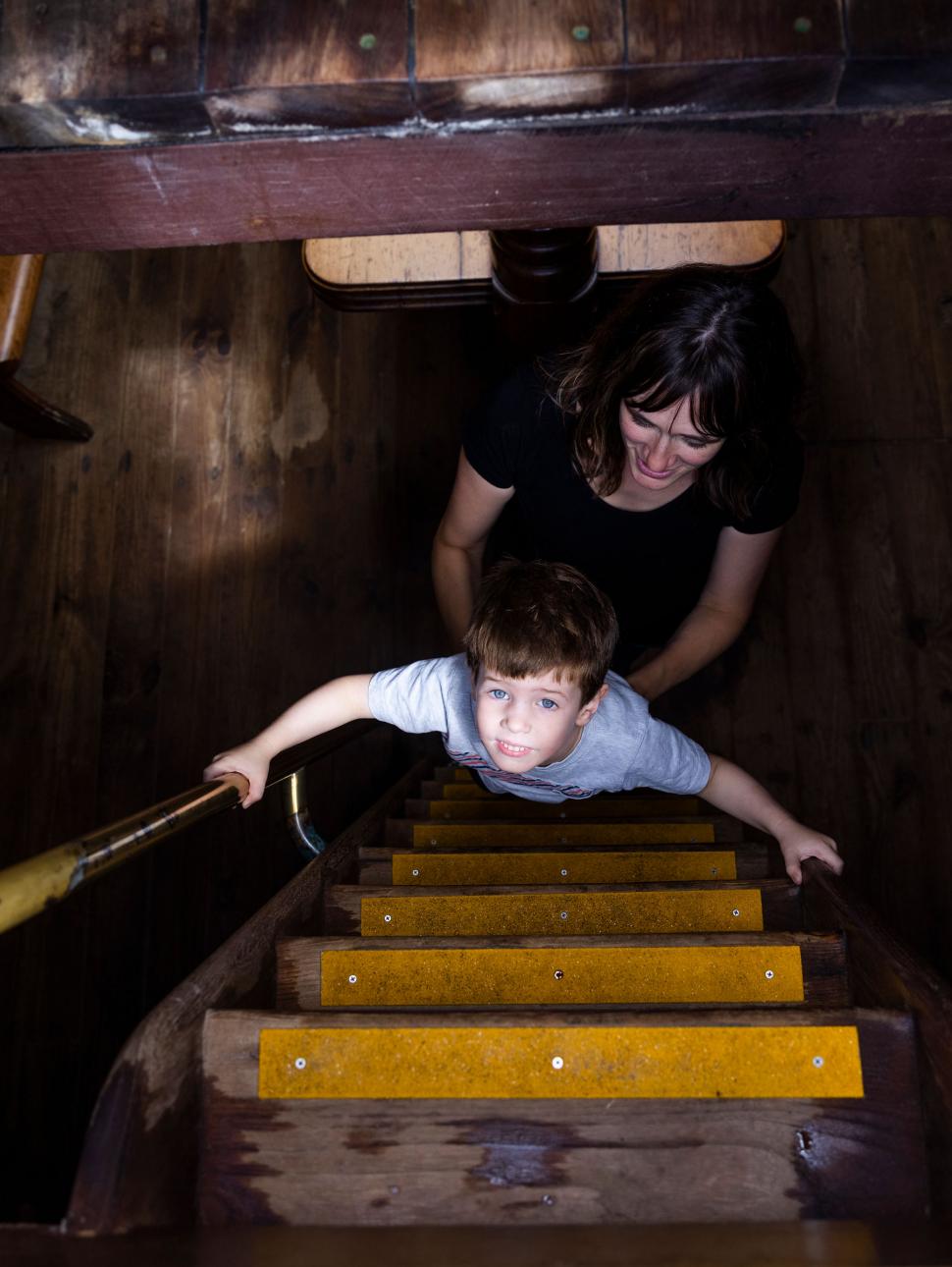 Child looks up from the middle of a wooden ship