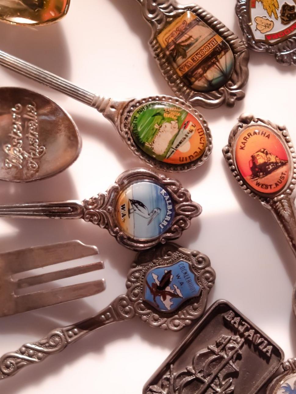 Several old spoons laid out on a white background