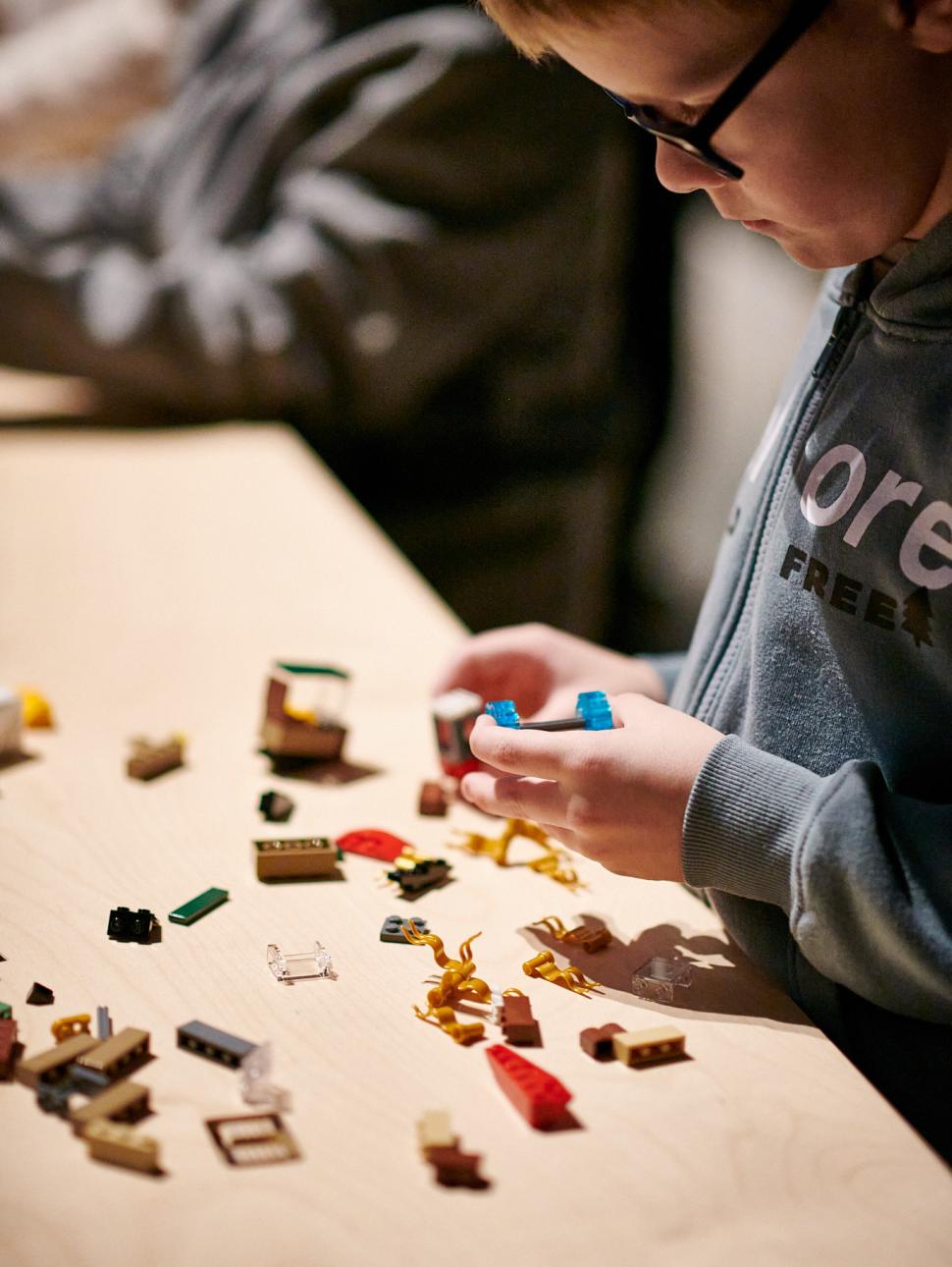 Image of child building LEGO ship using LEGO bricks 