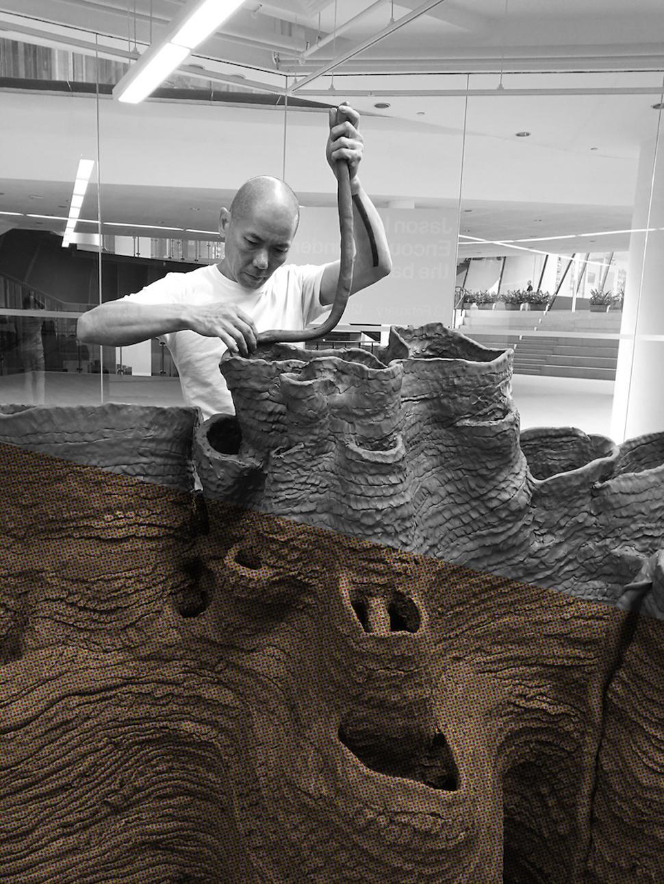 Artist Jason Lim sculpts a large mound of clay