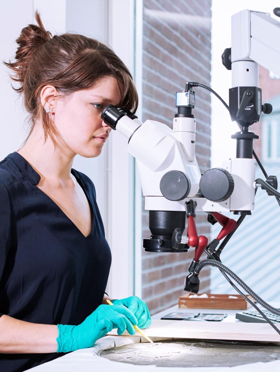 An image of conservation specialist Tamar Davidowitz inspecting the famous 400 year old artefact, the Hartog Plate.