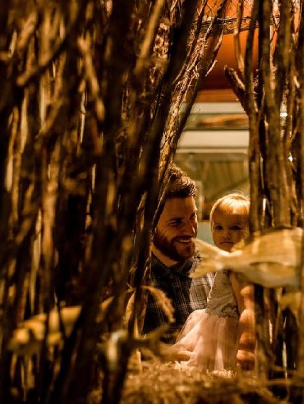 Image of a young girl being held by her dad looking through a underwater display