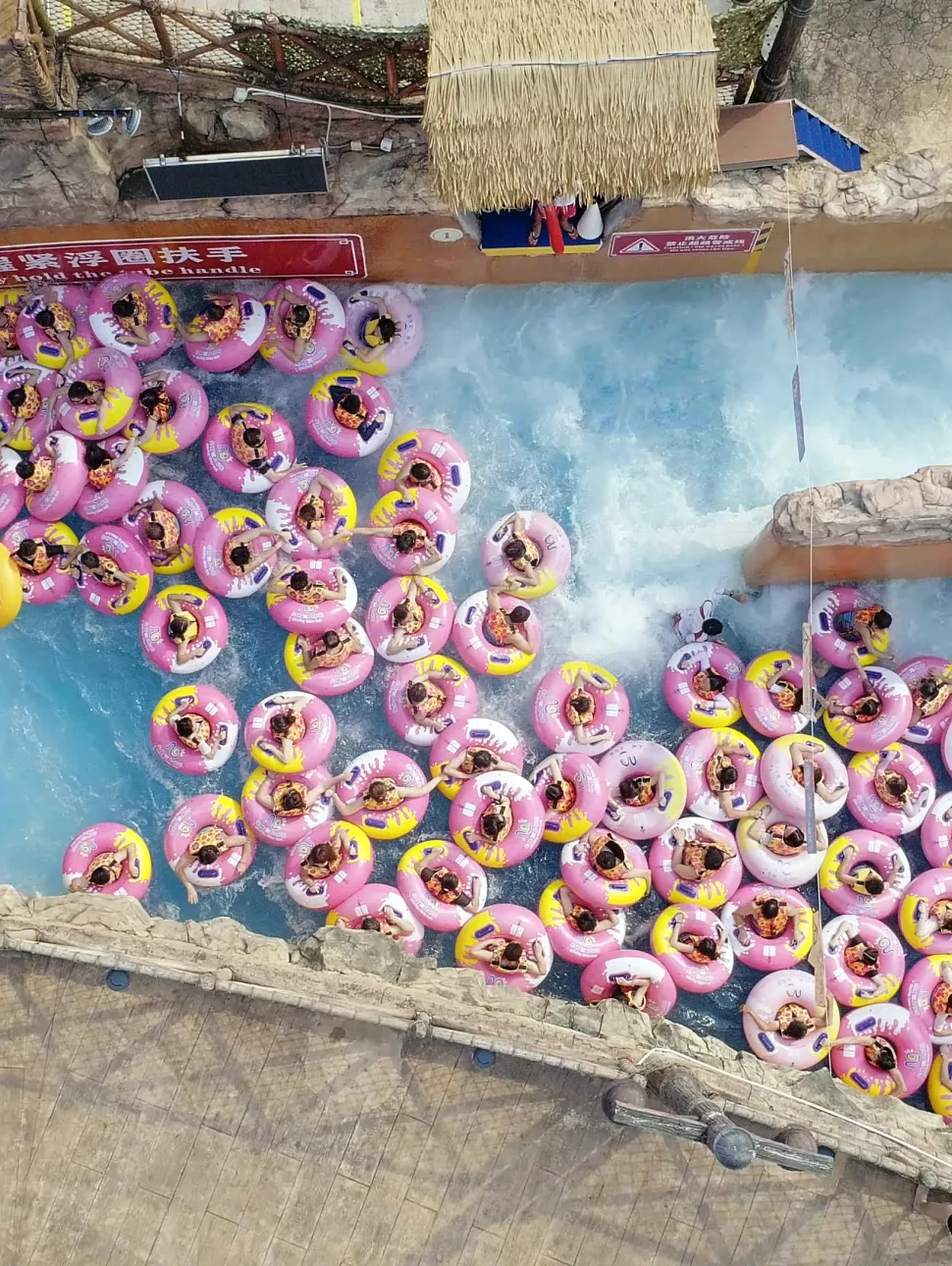 people in pink rubber rings in a river