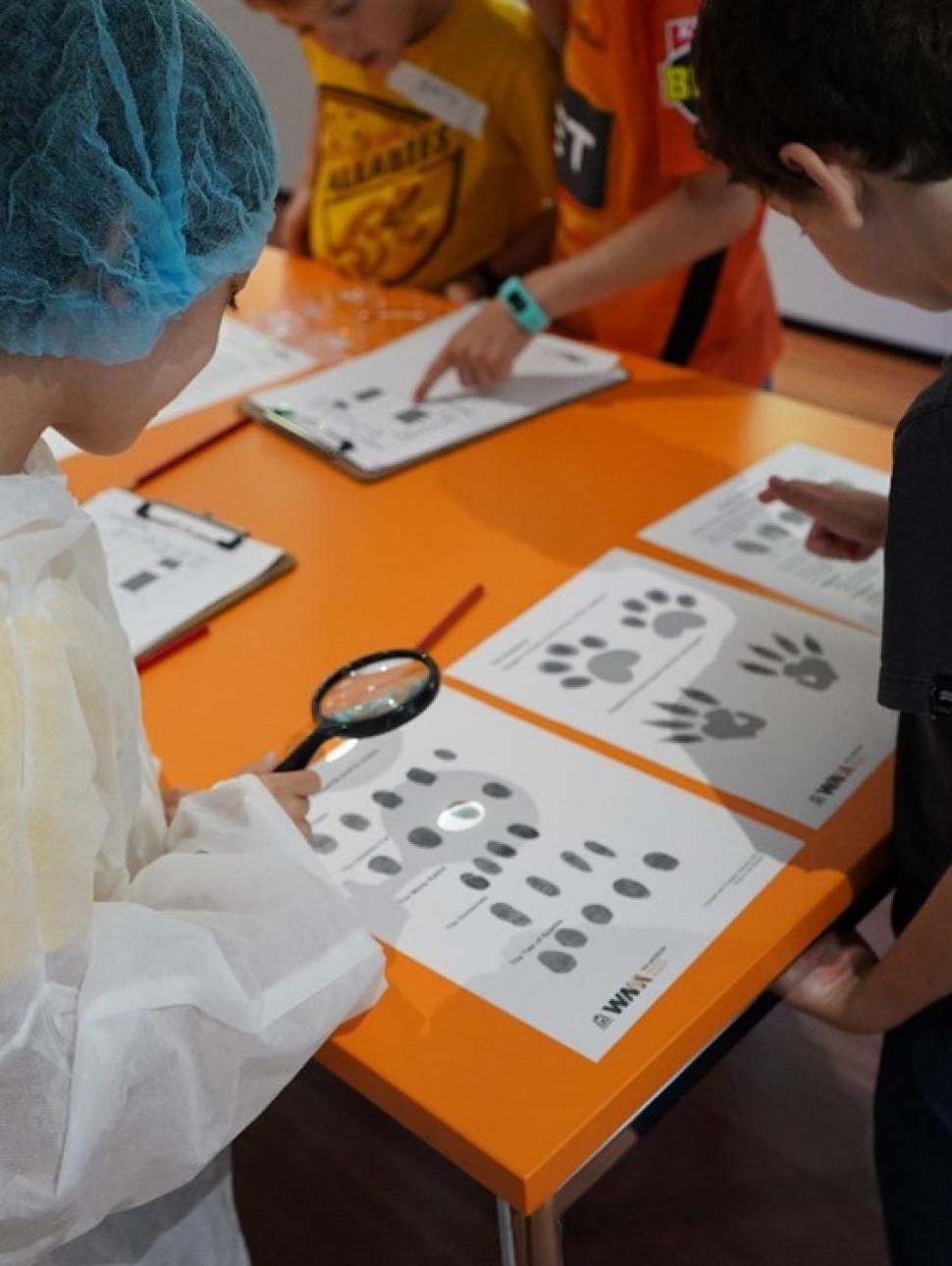 This imsage shows two boys undertaking a fingerprint forensic test